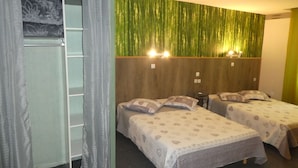 A hotel room with two single beds, a wardrobe, and a green wall with vertical lines. - Phoenix Hôtel (Béziers)