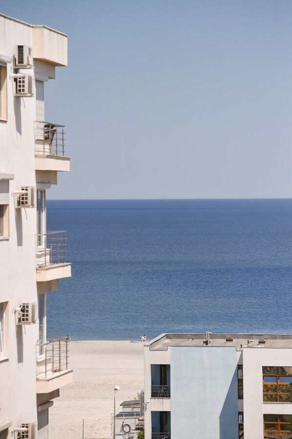A multi-story building with balconies overlooking a beach and the sea. - Masy MAMAIA Apartament (Constanta)