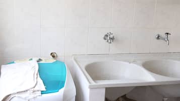 A bathroom with a white sink, two faucets, and a blue basin.
