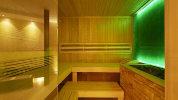 A sauna with wooden benches and a stone wall.