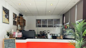 Ein Café-Interieur mit einer Theke, Kaffeemaschinen und einer Speisekarte.