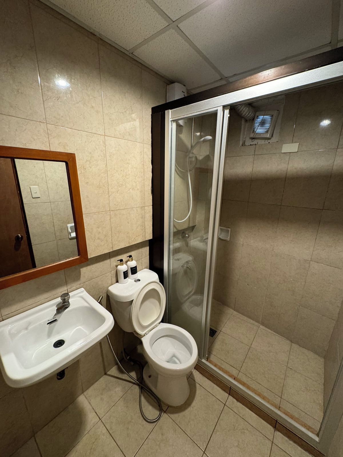 A bathroom with a sink, toilet, and glass-enclosed shower.
