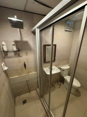 A modern bathroom with a glass shower enclosure, a separate toilet, and a sink. - Sj Mansion Hotel (San Jose)