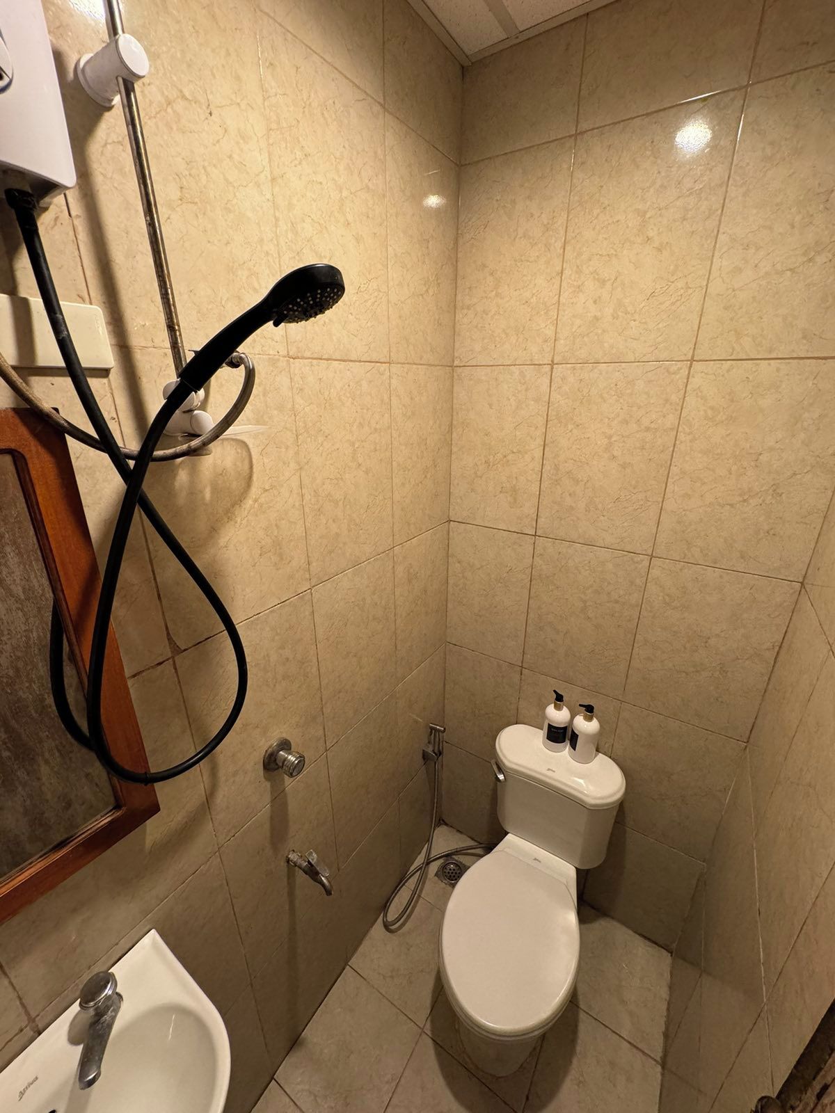 A small, tiled bathroom with a toilet, bidet, and sink.