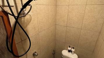 A small, tiled bathroom with a toilet, bidet, and sink.