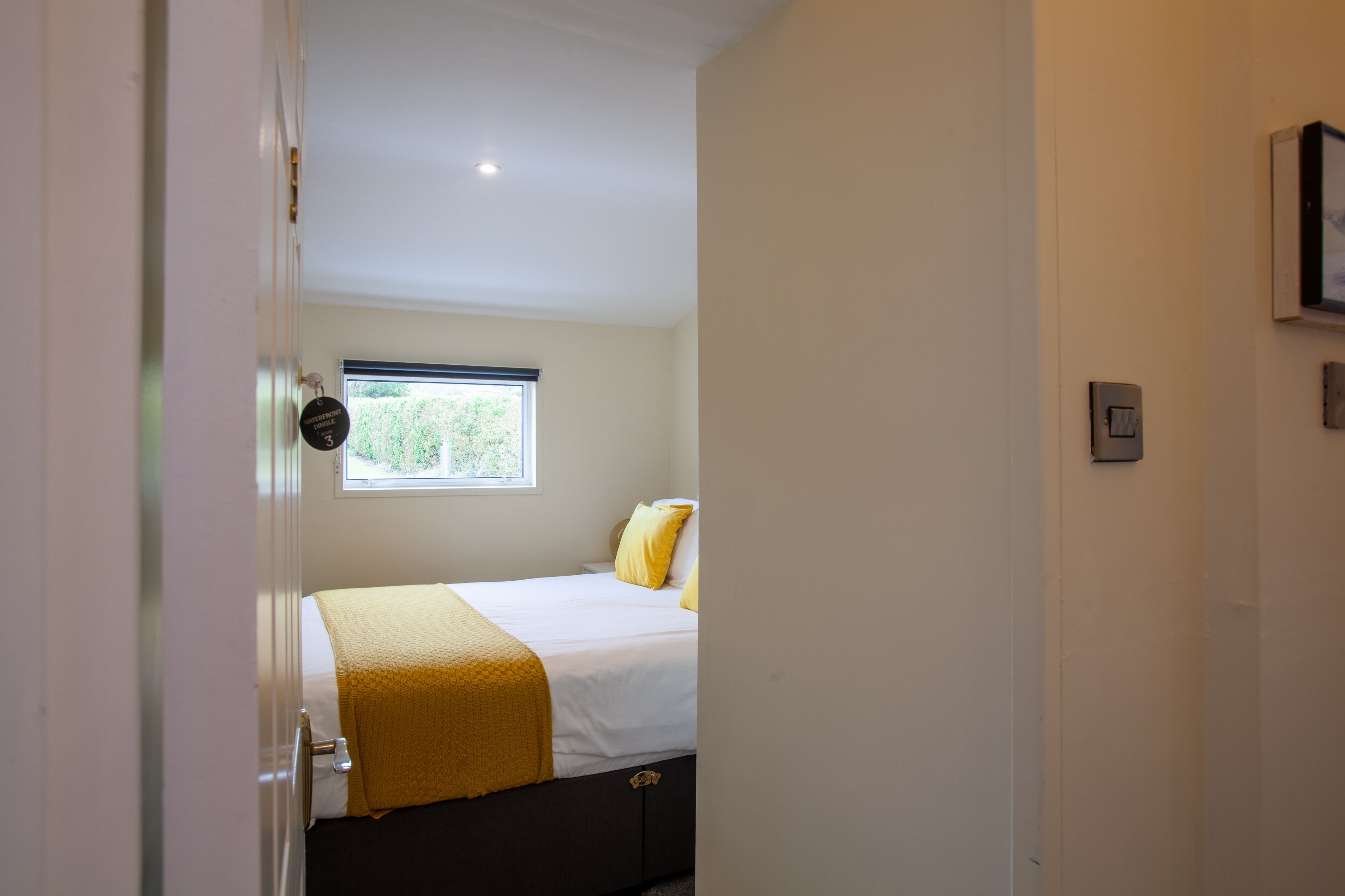 A bedroom with a bed, a window, and a door.