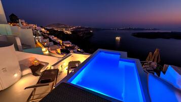 An infinity pool, a rooftop pool, pool umbrellas, sun loungers