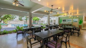 A restaurant with outdoor seating, a pool, and a view of the surrounding area. - Sawasdee Place Hotel (Pattaya)
