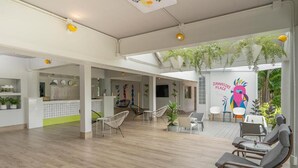 A spacious indoor area with wooden flooring, seating arrangements, and hanging plants. - Sawasdee Place Hotel (Pattaya)