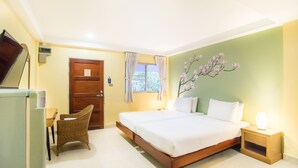 A bedroom with a bed, a chair, a nightstand, a TV, and a window with curtains. - Sawasdee Place Hotel (Pattaya)