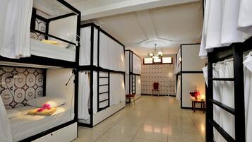 Habitació d'hotel amb literes, una taula petita amb un vas i una cadira.