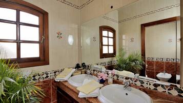 Ein Badezimmer mit zwei Waschbecken, einem großen Spiegel und einem Fenster.