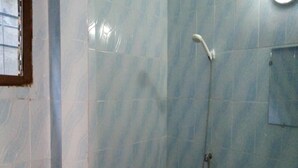 Een badkamer met een douche, wastafel en spiegel.