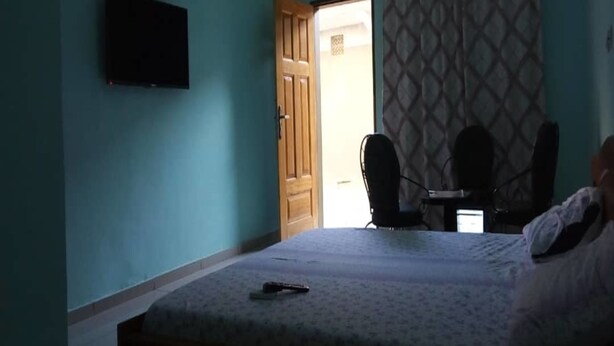 Een slaapkamer met een bed, een bureau en een stoel.