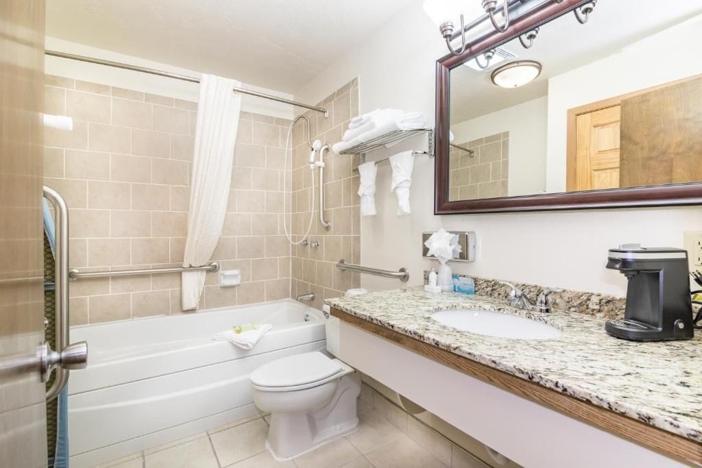 A bathroom with a bathtub, toilet, and sink.