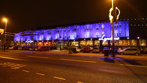 A building with a sign reading "Lyons" and multiple parked cars in front. - Lyndene Hotel (Blackpool)