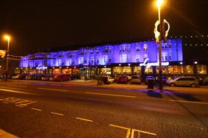 A building with a sign reading "Lyons" and multiple parked cars in front.