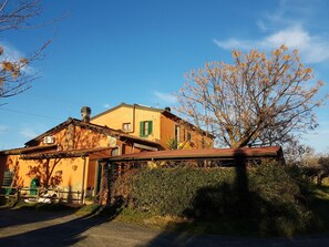 A two-story building with a sloped roof, a chimney, and a small porch. - Agriturismo Il Giogo (Rosignano Marittimo)