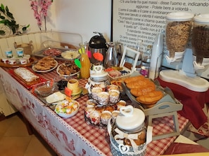 Une table de buffet garnie de différents plats, avec une pancarte en arrière-plan.