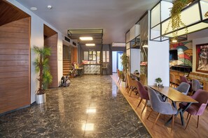 A modern interior with a marble floor, wooden accents, and a long dining table with chairs. - Sirkeci Ersu Hotel (Istanbul)