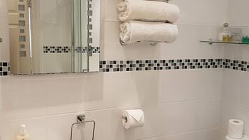 A bathroom with a sink, toilet, and a towel rack with folded towels.