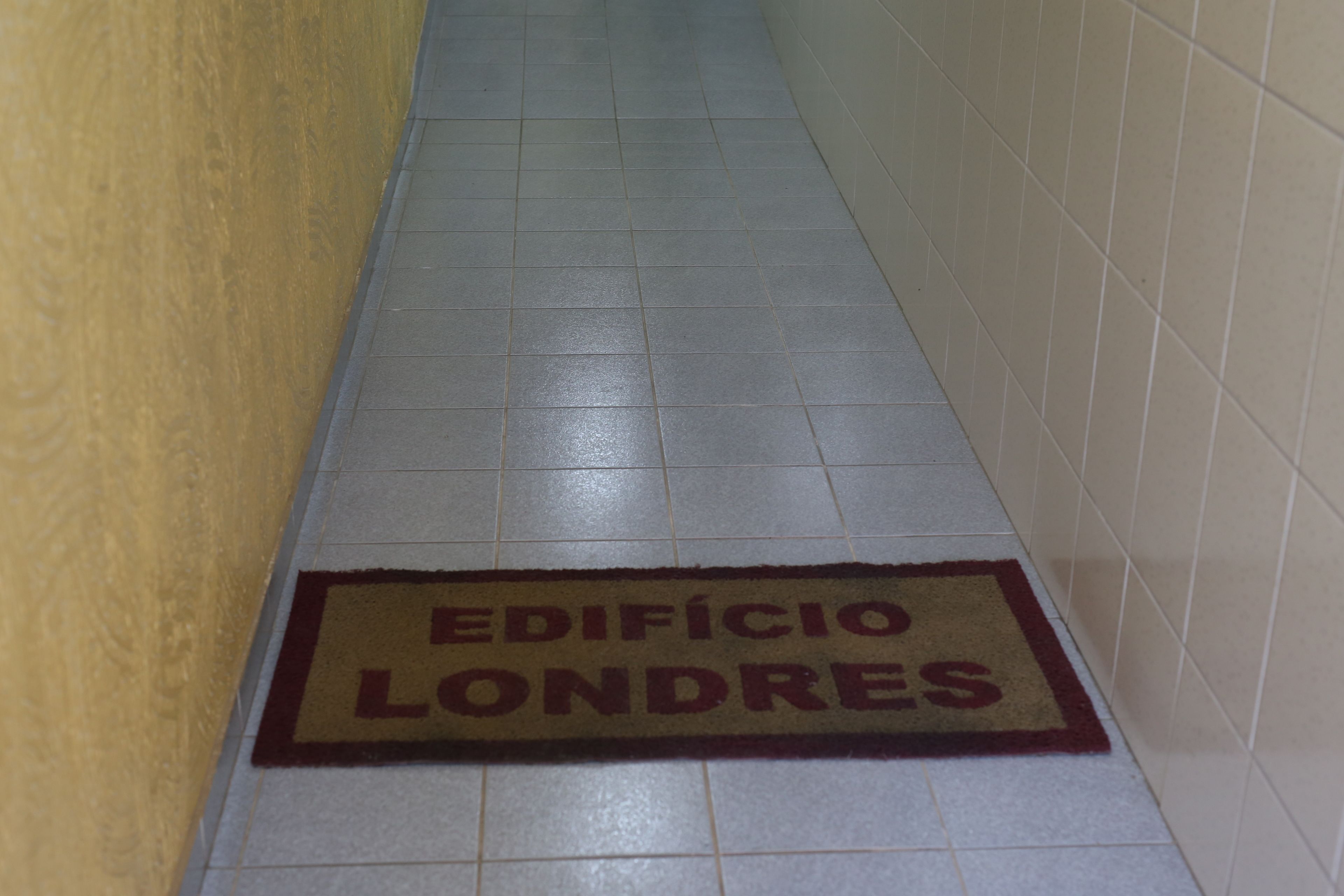 Un pasillo con un felpudo que dice "EDIFICIO LONDRES".
