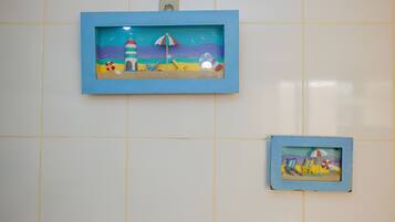 Two framed beach scenes on a tiled wall.