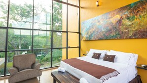 Una habitación de hotel moderna con una cama grande, un banco y una silla.