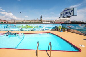 Una piscina al aire libre de temporada, sombrillas