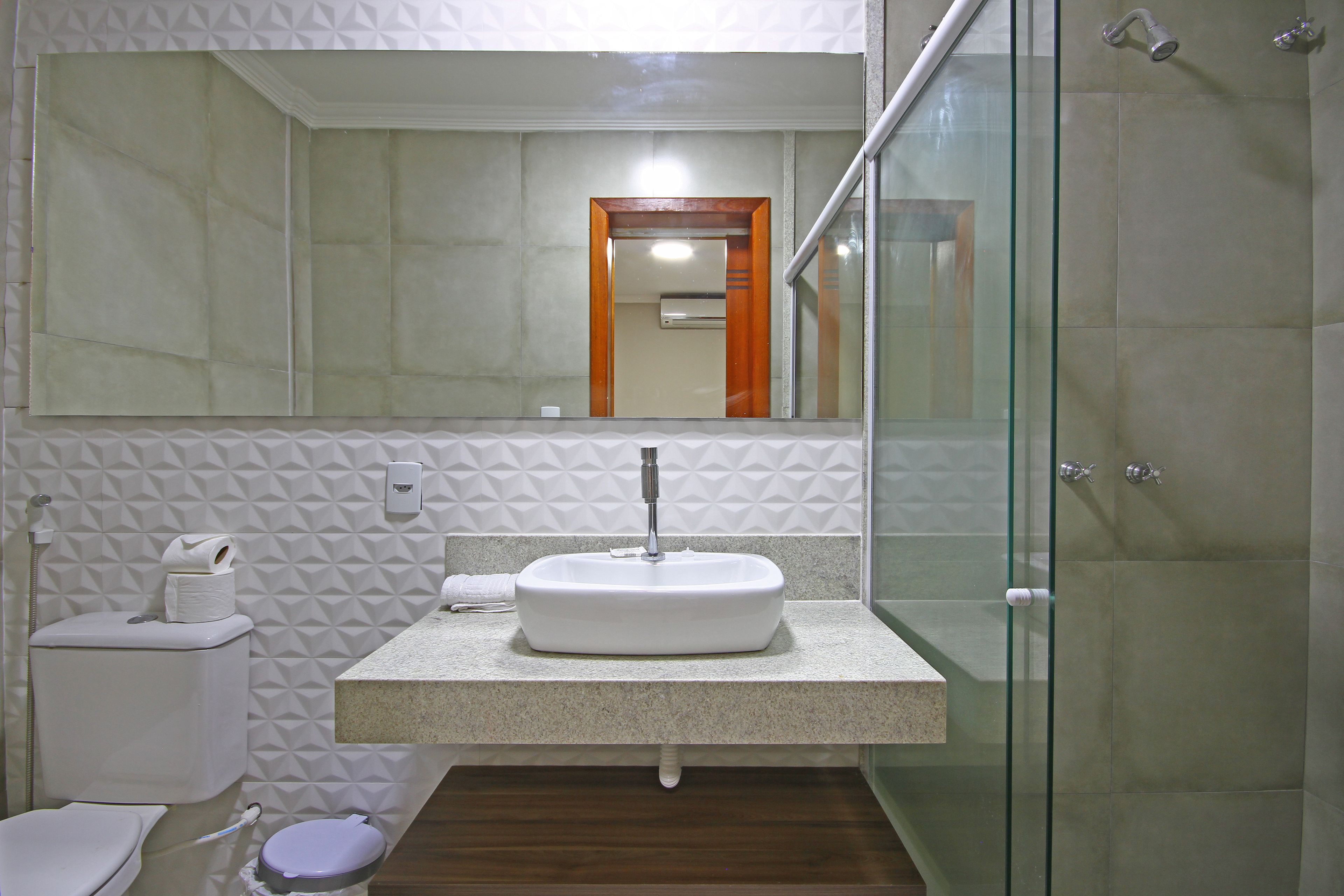 A bathroom with a white sink, toilet, and shower.
