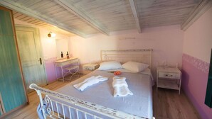 Un dormitorio con cama, dos mesitas de noche, un escritorio y un espejo.