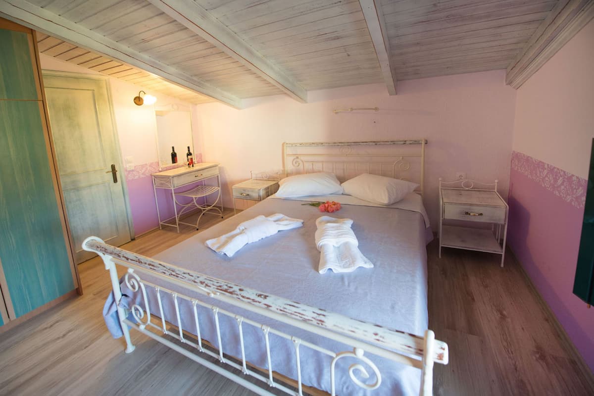 Un dormitorio con cama, dos mesitas de noche, un escritorio y un espejo.