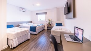 A hotel room with two single beds, a desk with a laptop, a TV on the wall, and a window with a view. - Prime Hotel Ponta Porã (Ponta Pora)