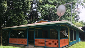 Ett hus med en veranda, en satellitmottagare och en basketkorg.