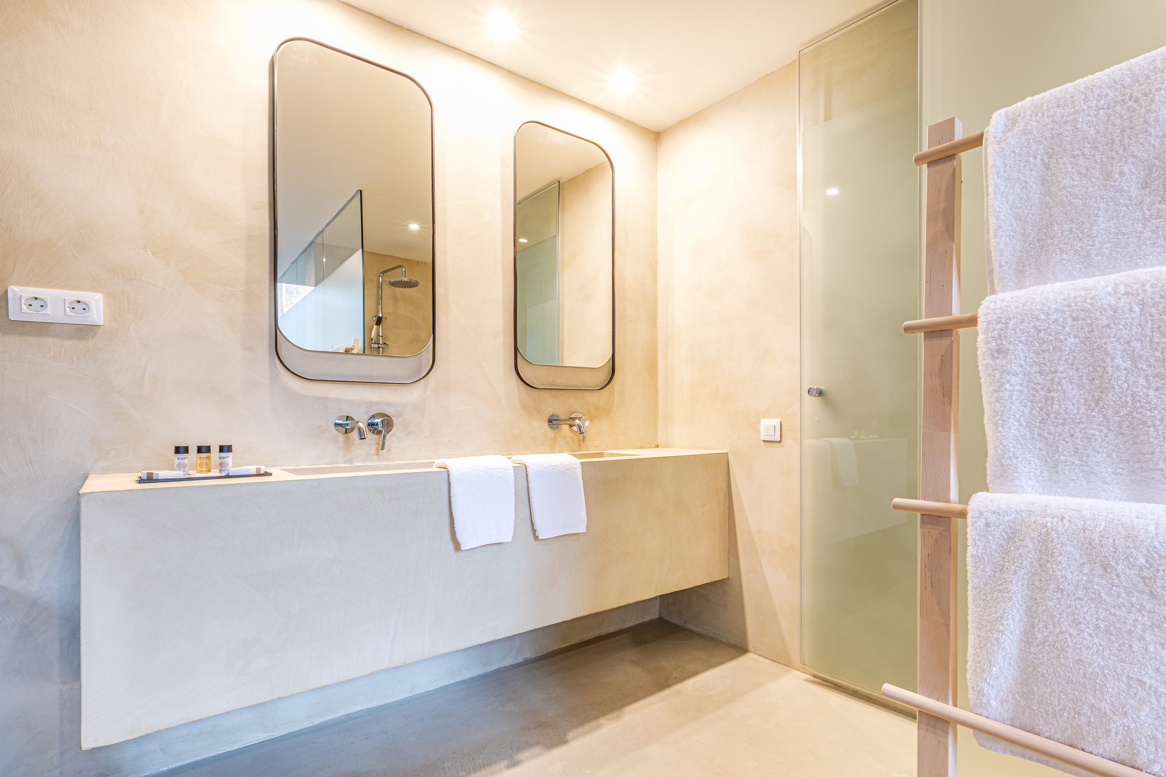 Un baño moderno con un espejo grande, una bañera y un box de ducha de cristal.