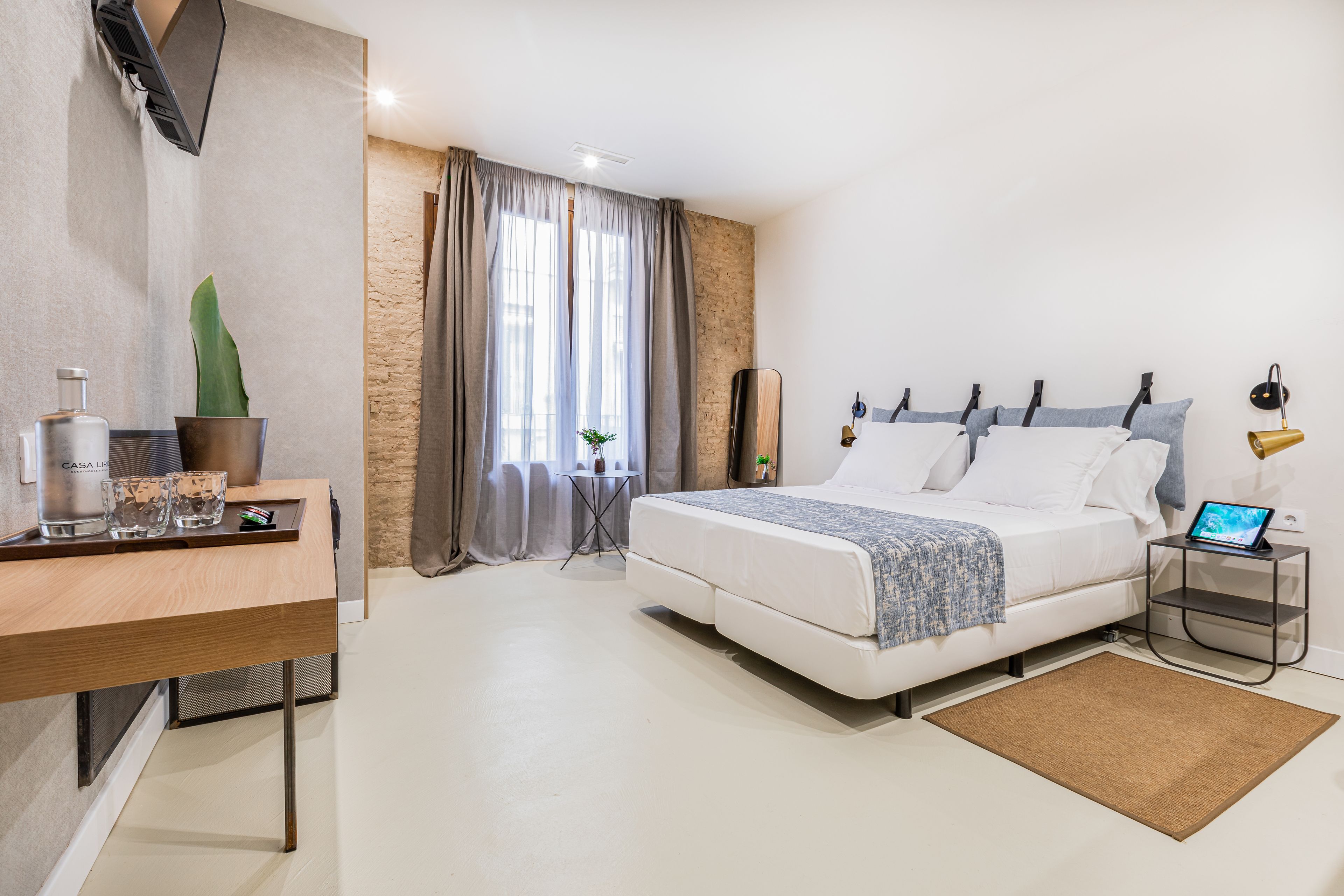 Un dormitorio moderno con cama, mesita de noche y escritorio con silla.