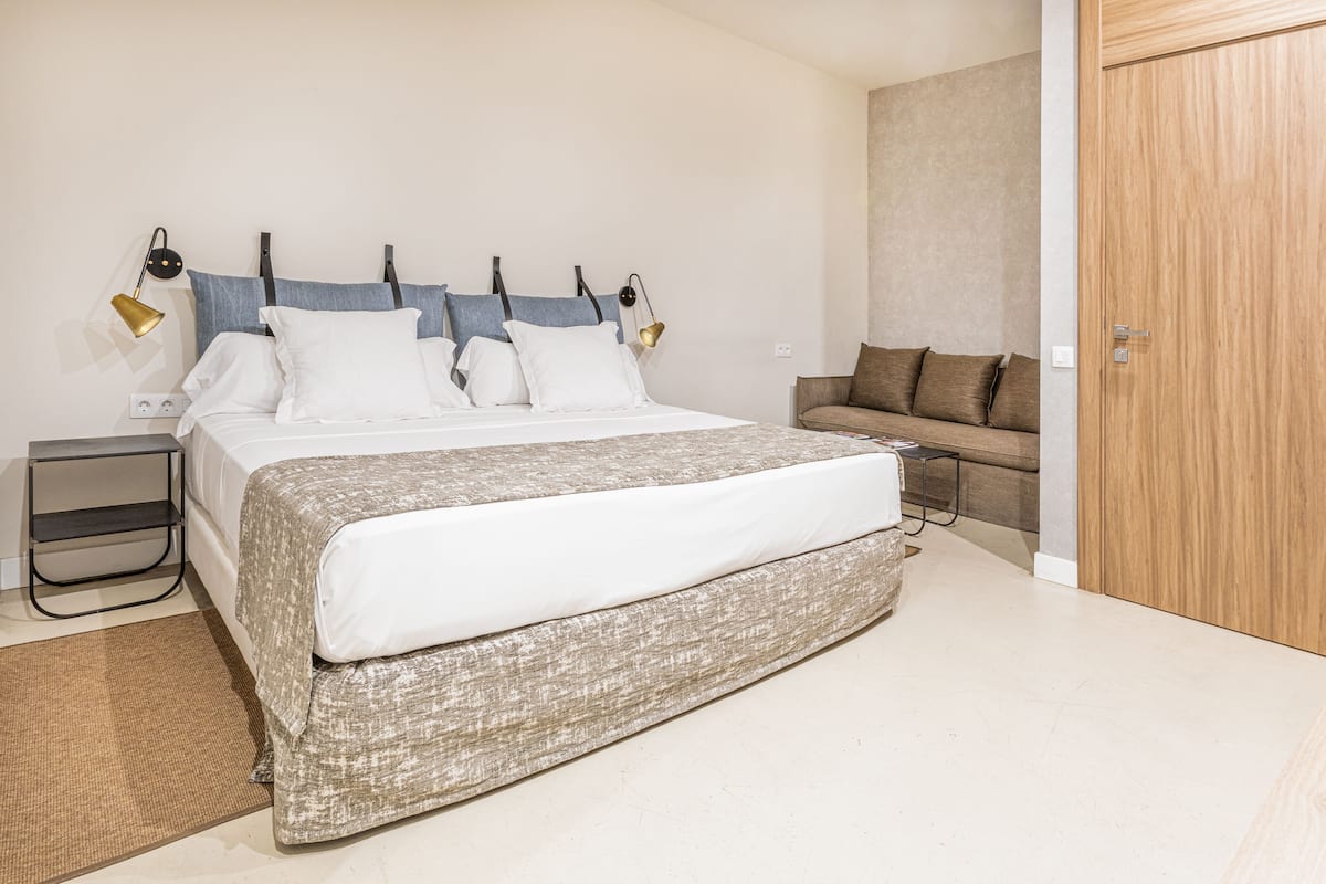 Ein Schlafzimmer mit Bett, Nachttischen, einer Couch und einem Kleiderschrank.