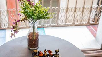 A table with a vase of flowers and chocolates.