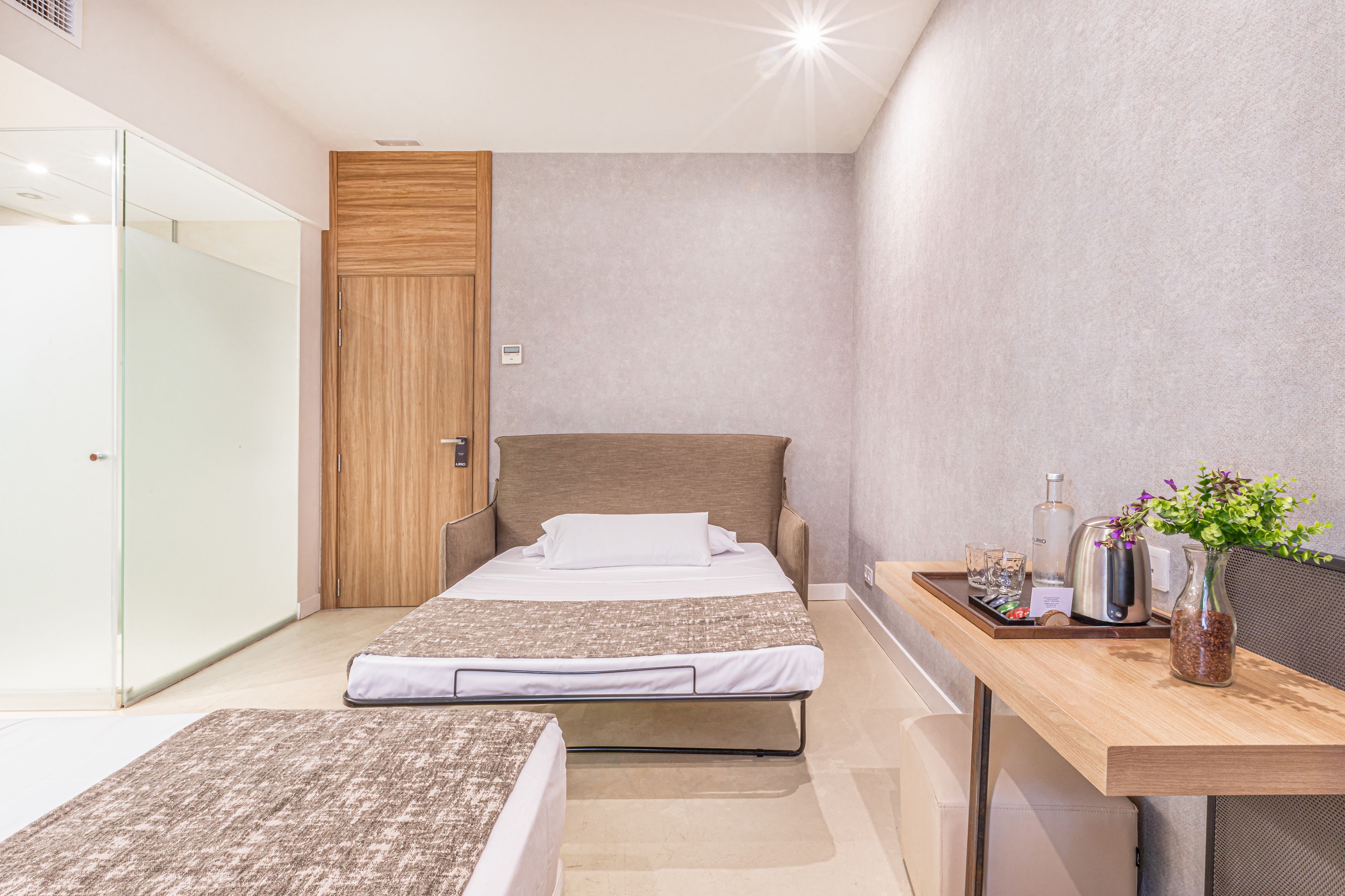 Un dormitorio moderno con cama, mesita de noche y velador.