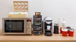 Eine Küchenzeile mit einer Siemens-Mikrowelle, einer Kaffeemaschine und diversen Küchenutensilien.