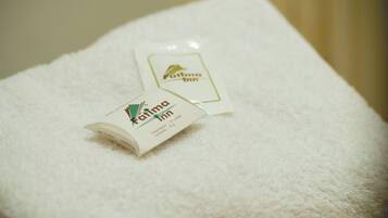 Un asciugamano bianco con un piccolo kit di articoli da bagno dell'Inn Fatima.