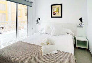 A hotel room with a bed, a view of the outside balcony, and a framed picture on the wall. - Hostel Las Palmas I (Carboneras)