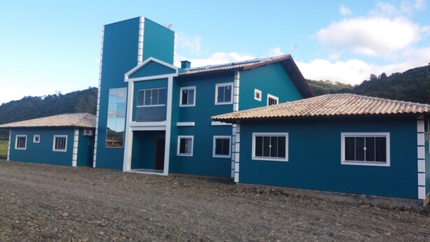 A large blue building with multiple windows and a central entrance. - Pousada Abraco Serrano (Urubici)