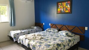 A room with two beds, a blue wall, and a colorful abstract painting. - Pousada Abraco Serrano (Urubici)