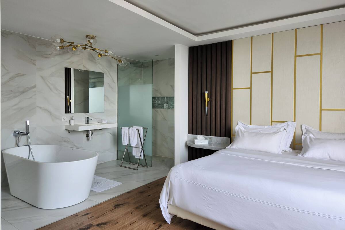 A modern bathroom with a freestanding bathtub, a vanity with a mirror, and a shower enclosure.