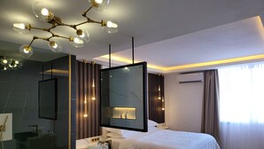 Une chambre moderne dotée d’un grand lit, d’une coiffeuse intégrée, d’un grand miroir et d’un lustre original.