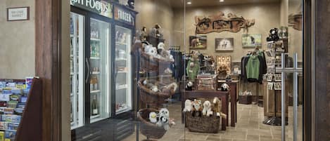 Eine gemütliche Hotelhalle im Boutique-Stil mit einer 'Fresh Foods'-Abteilung für Tiefkühlkost, Korbwägen mit kuscheligen Spielzeugen und verschiedenen Souvenirs.