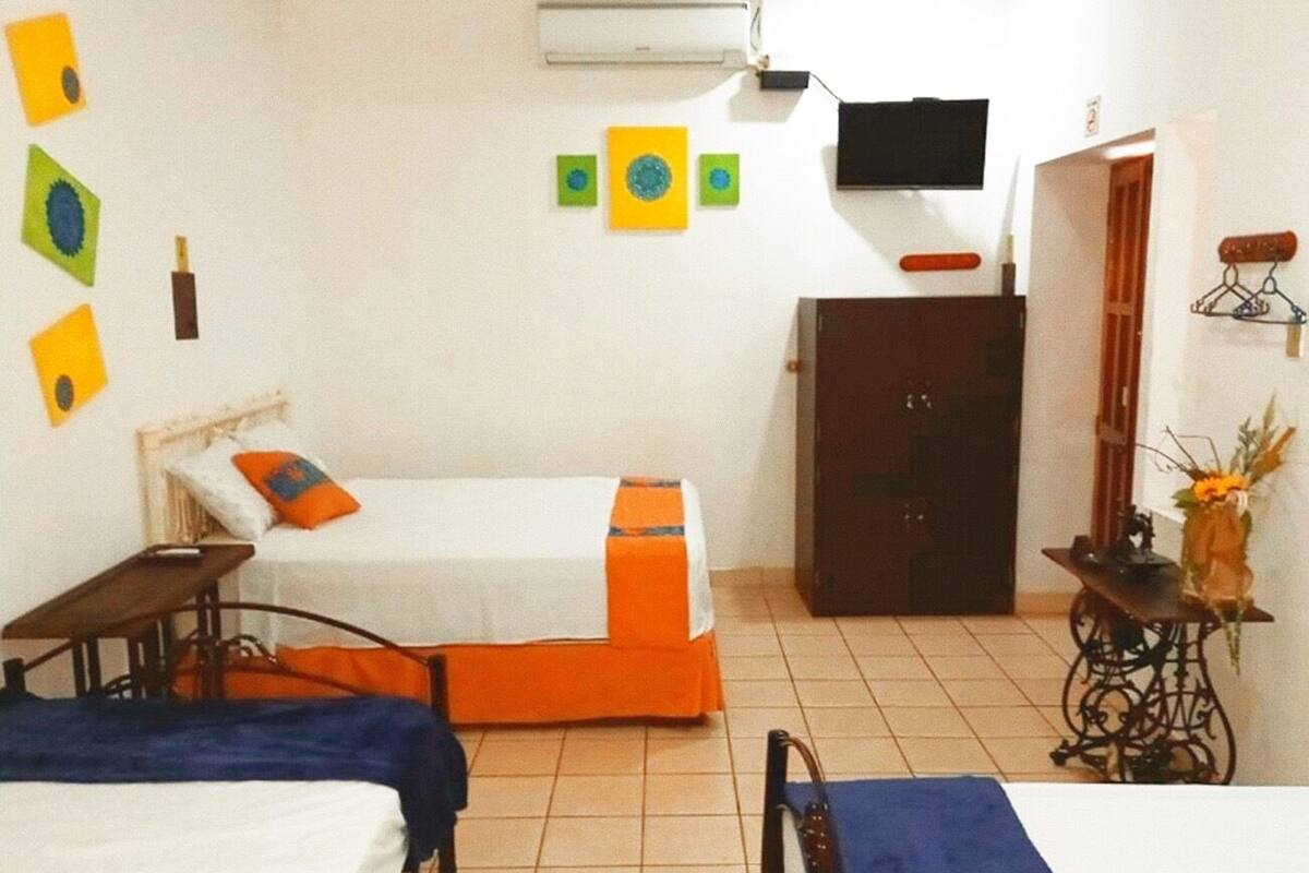 A room with two beds, a TV, a small table, and a cabinet.