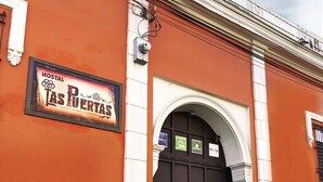 Un edificio con un letrero que dice "Hostal Las Puertas".
