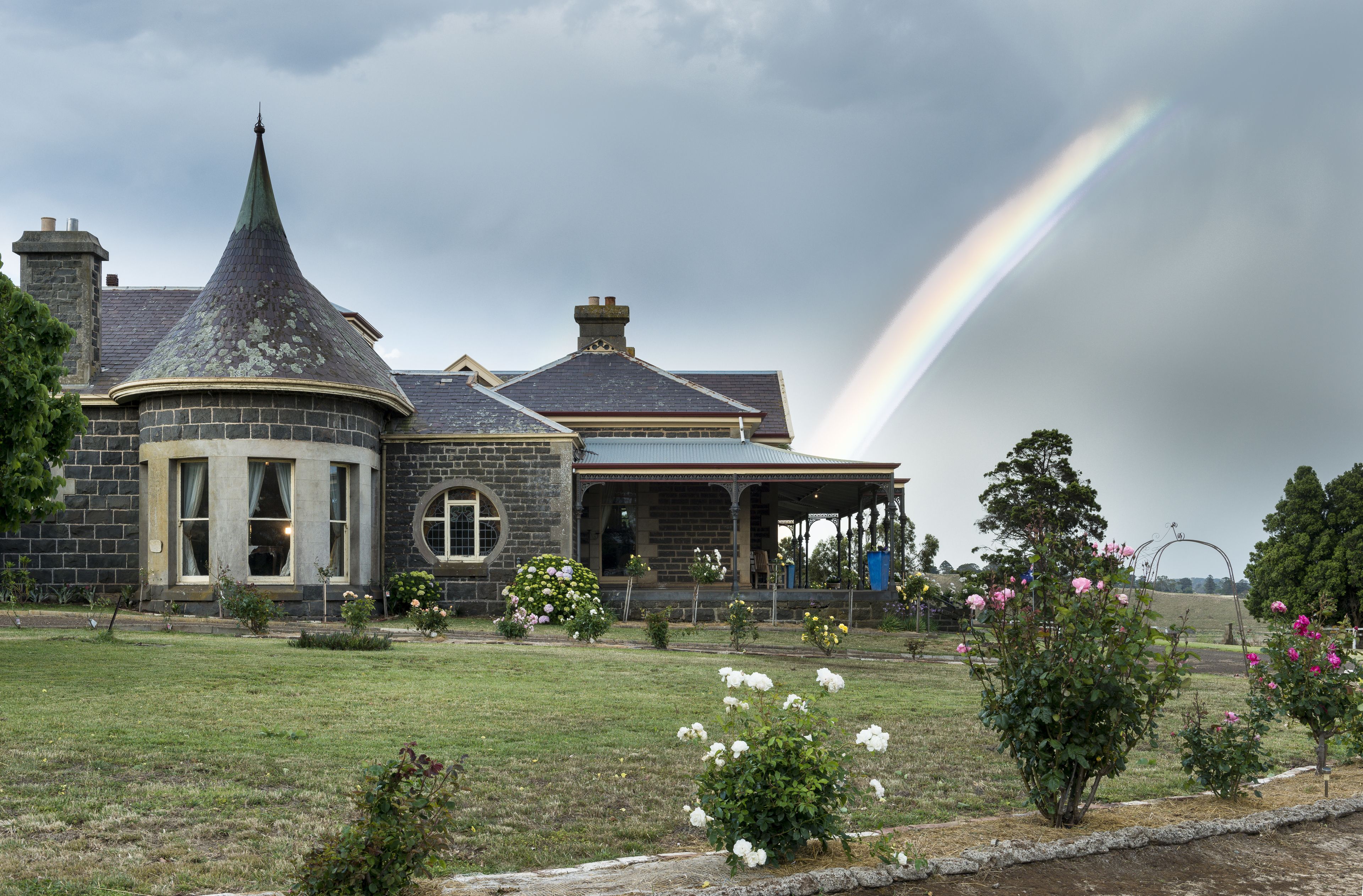 A large house with a distinctive turret and a covered porch.
